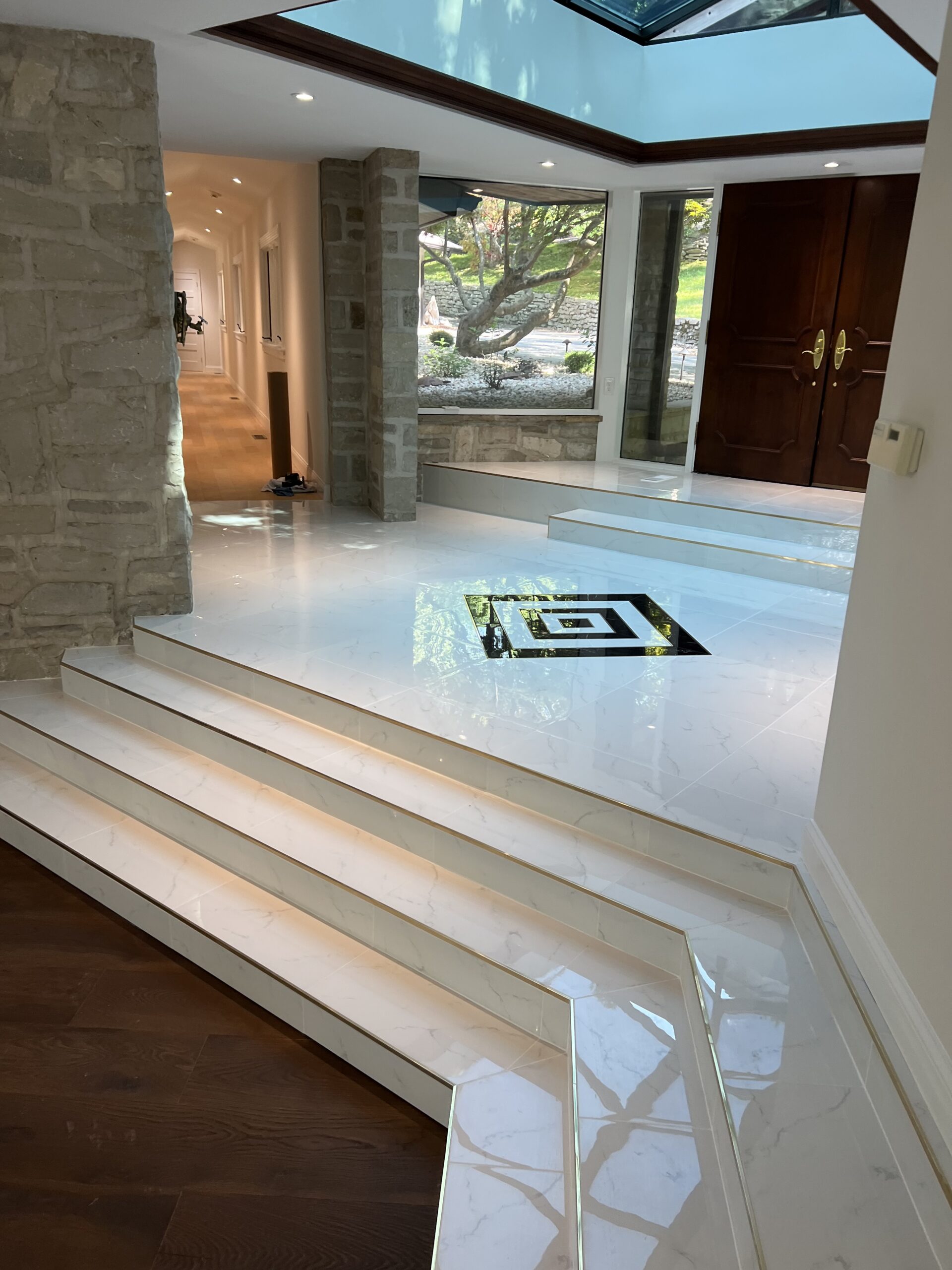 Black and white tiles in square pattern with tile stairs and wooden floor in view