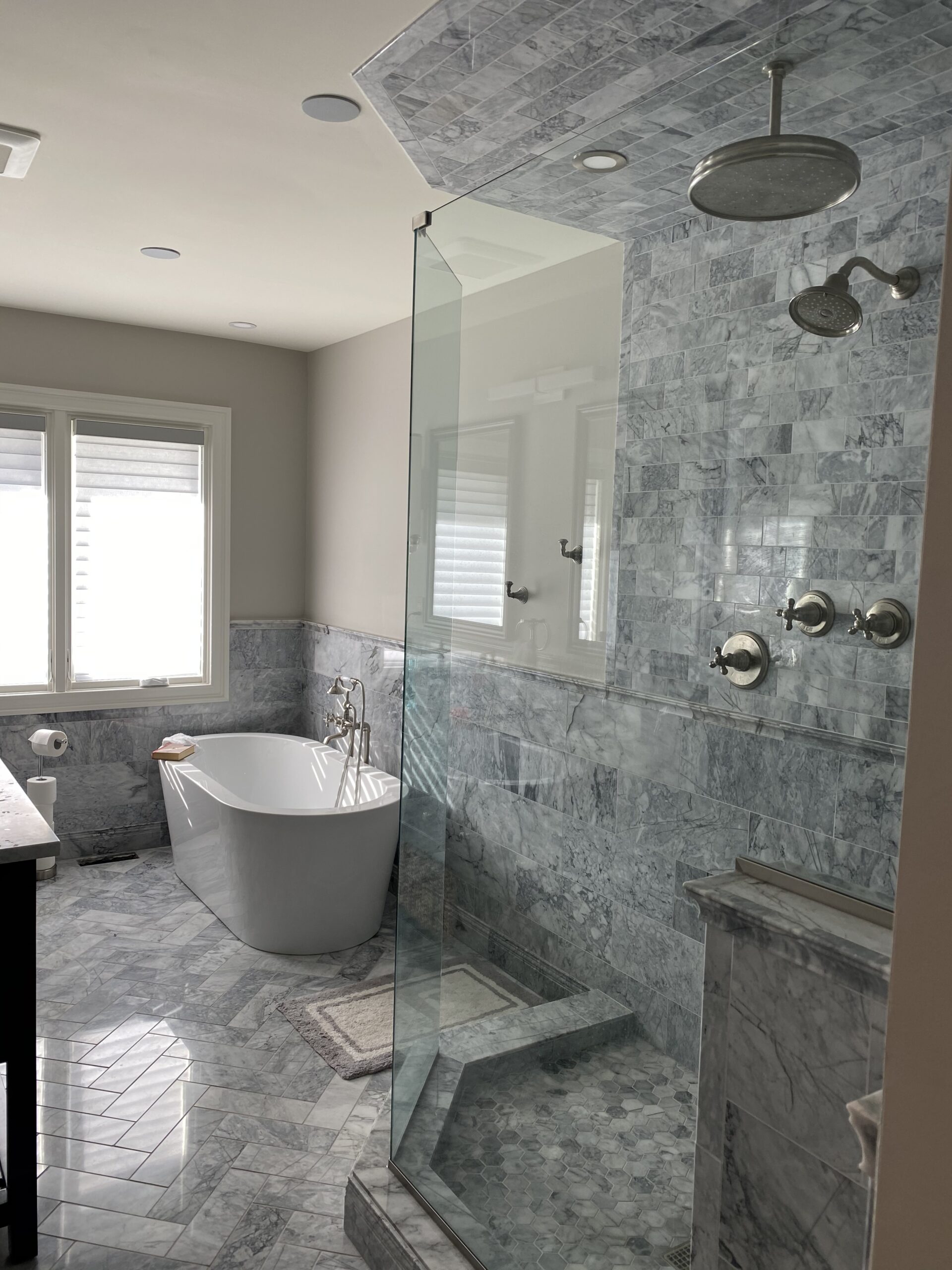 Tiled bathroom with bathtub and windows